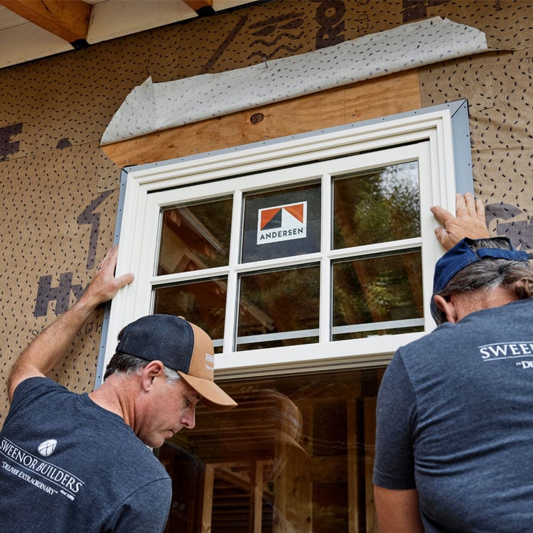 two contractors replacing window on home