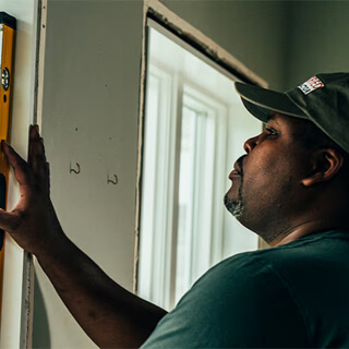 Contractor measuring and leveling a window