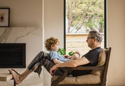 dad sitting in chair with son on his lap